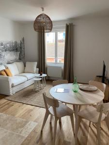 ein Wohnzimmer mit einem Tisch und einem Sofa in der Unterkunft Hilo Charming Appartment Saint Laurent Sur Sane in Saint-Laurent-sur-Saône