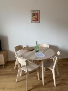 einem weißen Tisch mit zwei Stühlen und einer Vase darauf in der Unterkunft Hilo Charming Appartment Saint Laurent Sur Sane in Saint-Laurent-sur-Saône
