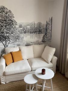 ein Wohnzimmer mit einem weißen Sofa und einem Gemälde in der Unterkunft Hilo Charming Appartment Saint Laurent Sur Sane in Saint-Laurent-sur-Saône