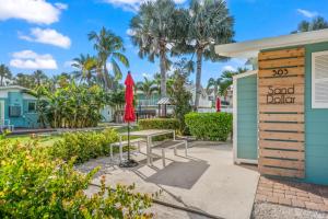 een patio met een bank, een asand-dollarteken en palmbomen bij MI Happy Place Sand Dollar 2 in Holmes Beach