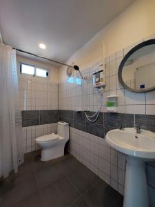 bagno con servizi igienici, lavandino e specchio di Raintrary House a Nakhon Phanom