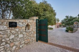 a stone wall with a green door in front of it at Jessica Luxury Villa in Agios Nikolaos