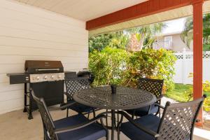 een patio met een tafel en stoelen en een grill bij Bollinger Duplex Both Sides in Holmes Beach