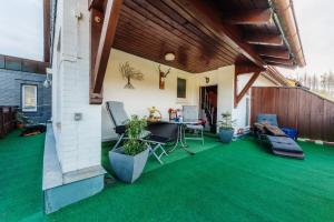 d'une terrasse avec de la pelouse verte, une table et des chaises. dans l'établissement Haus Tippe, à Braunlage