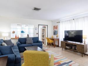 ein Wohnzimmer mit blauen Sofas und einem Flachbild-TV in der Unterkunft Bollinger Duplex, A in Holmes Beach