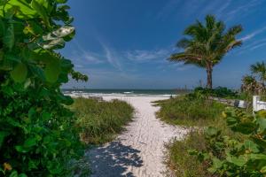 een pad naar het strand met een palmboom bij Bollinger Duplex, A in Holmes Beach