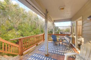 a porch with two chairs and a table on it at Well-Equipped Emerald Isle Townhome Pets Welcome! in Emerald Isle