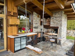 an outdoor kitchen with a shower and a stone wall at Villa - VALL DI VALL in Pirin Golf & Country Club in Razlog
