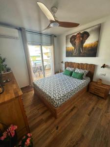 a bedroom with a bed and a painting of an elephant at Sunsetmare Vacational Apartment in Roses