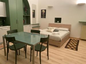 トリノにあるL’angolo infinitoのベッドルーム1室(ベッド1台、ガラスのテーブル、椅子付)