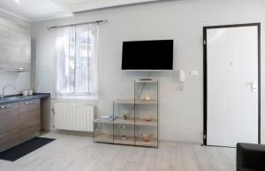 een woonkamer met een flatscreen-tv aan de muur bij Casa Sanremo Tiziano in Sanremo