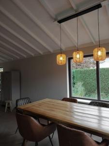 een eetkamer met een houten tafel en stoelen bij Luxe familiehuis 8p nabij bos en hei op de Veluwe in Putten