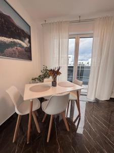 ein weißes Esszimmer mit einem Tisch und Stühlen in der Unterkunft Ferienwohnung-Weinstadt in Weinstadt