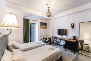 Pokój hotelowy z 2 łóżkami i biurkiem w obiekcie Hotel Roshe Gudauri w mieście Gudauri