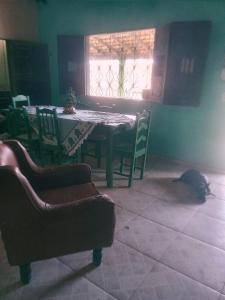 un tavolo da pranzo e sedie con un gatto sdraiato sul pavimento di Aloha LC Hostel a Luis Correia