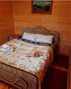 a bed in a room with a wooden wall at Cottage in Surami in Surami