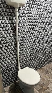 um WC branco numa casa de banho com papel de parede preto e branco em Condomínio luiza em Rio Branco