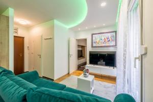 uma sala de estar com um sofá verde e uma televisão em Noemi Luxury Apartment em Solin