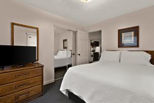 a bedroom with a bed and a flat screen tv at Traverse Bay Inn in Traverse City