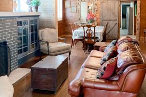 - un salon avec un canapé en cuir et une table dans l'établissement Red Door Cottage, à Waco