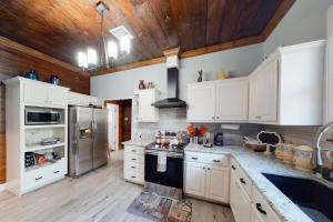 une cuisine avec des armoires blanches et des appareils en acier inoxydable dans l'établissement Red Door Cottage, à Waco
