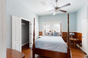 - une chambre avec un lit et un ventilateur de plafond dans l'établissement Red Door Cottage, à Waco