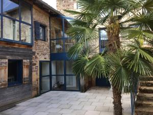 a palm tree in front of a building at Lumineuse Et Spacieuse Maison Style Loft in Saint-Amour-Bellevue