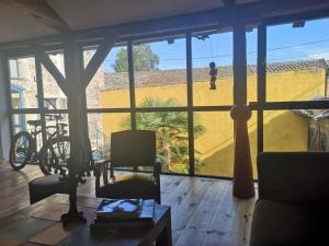 una sala de estar con una gran ventana con un niño jugando en Lumineuse Et Spacieuse Maison Style Loft en Saint-Amour-Bellevue