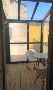 een kamer met een tafel en stoelen en een raam bij Lumineuse Et Spacieuse Maison Style Loft in Saint-Amour-Bellevue