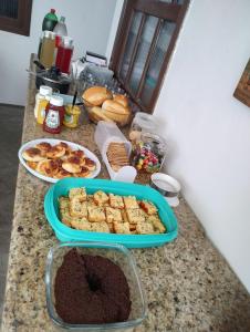 a counter with a tray of pastries and other food at Pousada Tropicália Tranquilidade a Beira Mar in Santa Cruz Cabrália