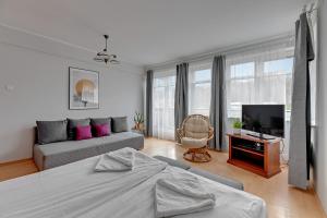 ソポトにあるWilla Halina by Grand Apartmentsのベッドルーム(ベッド1台、ソファ、テレビ付)