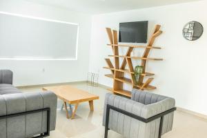 a living room with two chairs and a tv and a table at Lyra Vacation Rentals in Willemstad