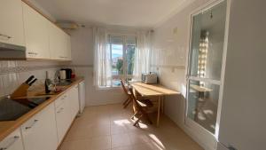 een witte keuken met een tafel en een raam bij Carihuela Plaza del Remo in Torremolinos