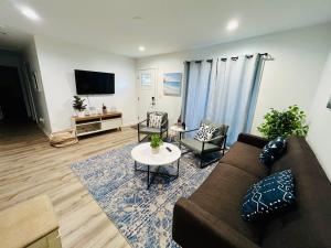 uma sala de estar com um sofá e cadeiras e uma televisão em Modern Home Near Uptown CLT, Airport and More em Charlotte