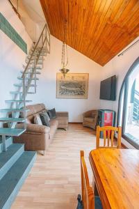 un soggiorno con una scala e un divano di El Duplex de Valsain a Sierra Nevada