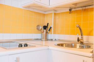 una cucina con lavandino e piastrelle gialle di El Duplex de Valsain a Sierra Nevada Altre 19 foto