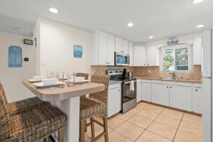 a kitchen with white cabinets and a table and chairs at MI Happy Place Sea Turtle 4 in Holmes Beach