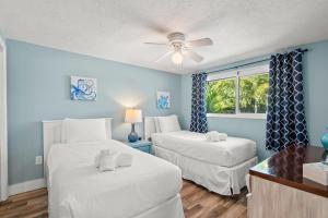 Duas camas num quarto com paredes azuis em MI Happy Place Sea Turtle 4 em Holmes Beach