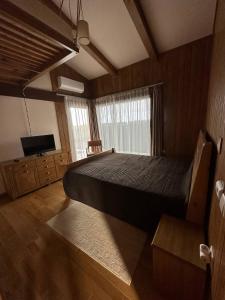 a bedroom with a large bed and a television at Villa - VALL DI VALL in Pirin Golf & Country Club in Razlog