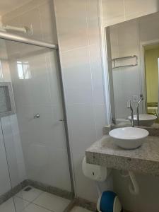 a bathroom with a glass shower and a sink at Hotel Treviso in Linhares