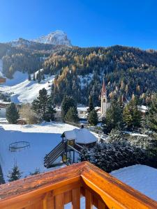 a view of a town in the snow with a church at Residence Ravisa in Selva di Val Gardena