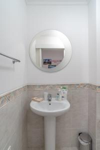 een badkamer met een witte wastafel en een spiegel bij Jardins da Ajuda Apartment in Funchal