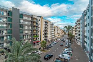 een stadsstraat met geparkeerde auto's en gebouwen bij Jardins da Ajuda Apartment in Funchal