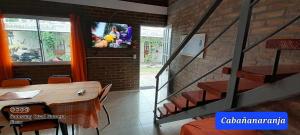 Habitación con mesa y TV en la pared. en LO DE MERY en Termas de Río Hondo