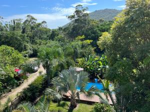 uma vista para um resort com uma piscina e árvores em Pousada O Bosque Casa 1 em Imbituba
