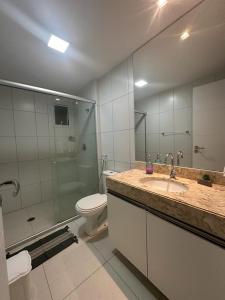 a bathroom with a toilet and a sink and a shower at Apartamento - Resort Golf Ville in Aquiraz