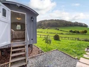 a train car sitting on the tracks in a field at Ewe Retreat Shepherds Hut in Hereford