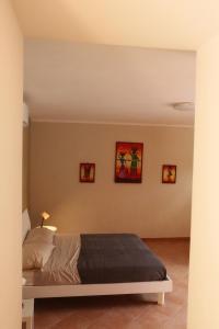 Piano的住宿－LadimoradiLu'，卧室配有一张床,墙上有三幅照片