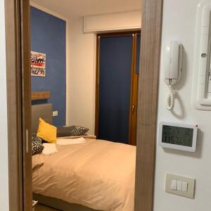 Pokój z łóżkiem i telefonem na ścianie w obiekcie alFiume B w mieście Tirano