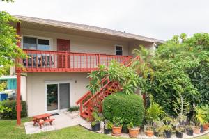 una casa con terrazza rossa e portico di A Wright Place a Holmes Beach